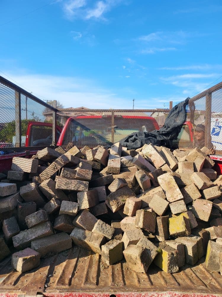 Truck bed loaded with broken pavers and concrete debris hauled off after a San Diego demolition job by Junk N Haul